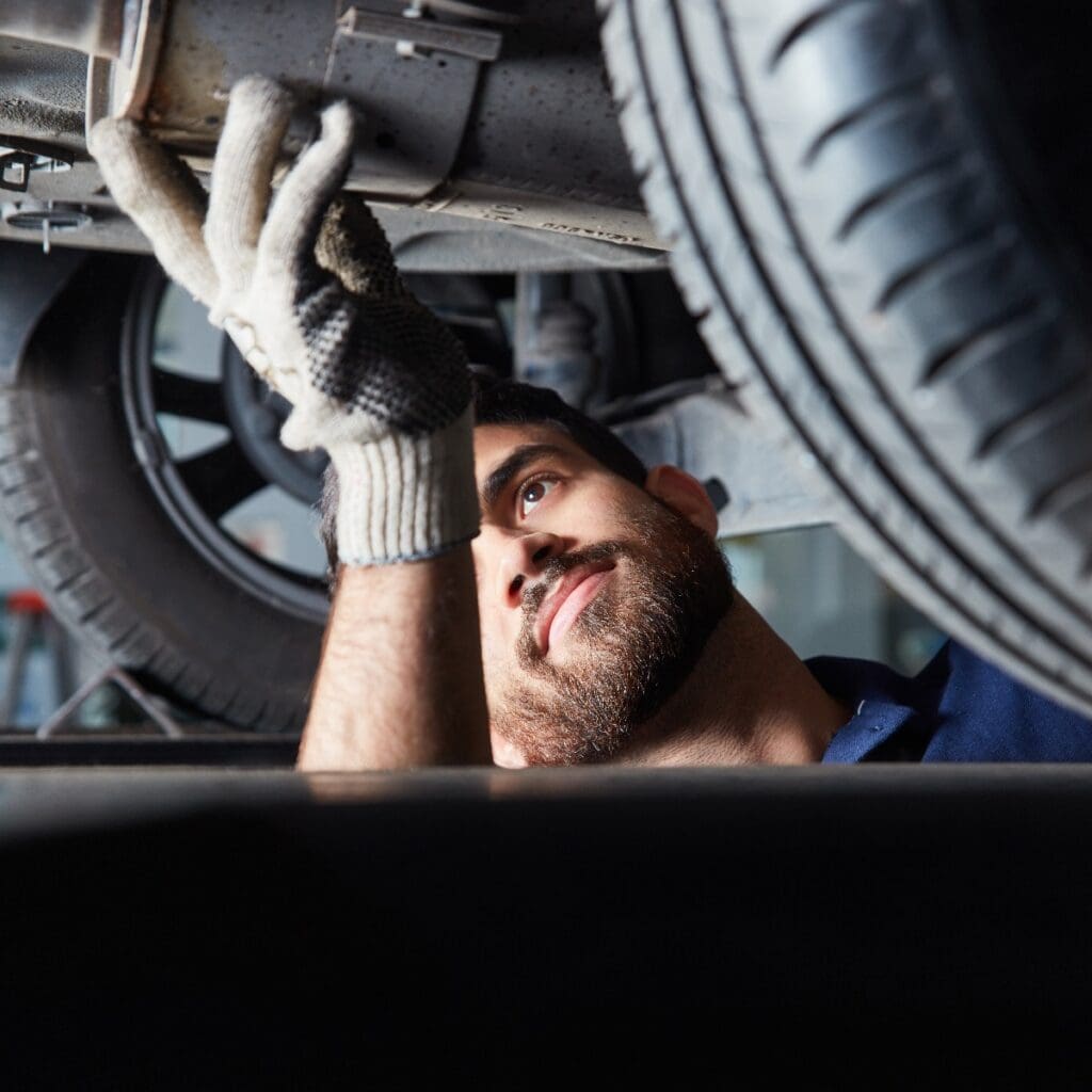 Mechatroniker bei der Reparatur von Auto Auspuff